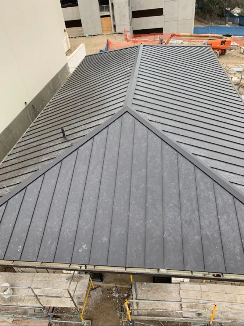 Commercial metal roof construction with crane equipment in Franklin